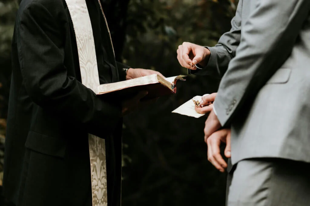 聖書を開いて結婚式の儀式を執り行う牧師