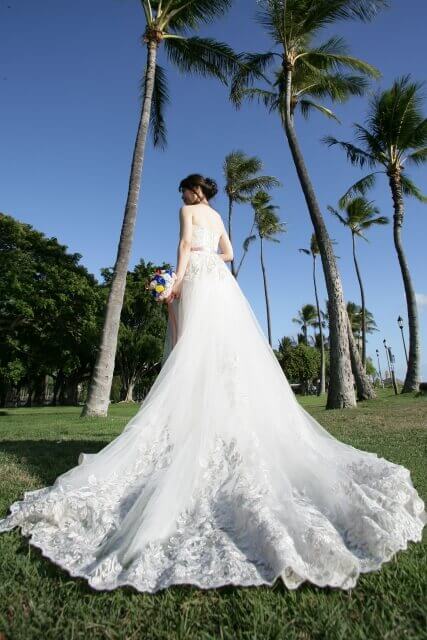 ウェディングドレス姿でリゾートガーデンに佇む新婦