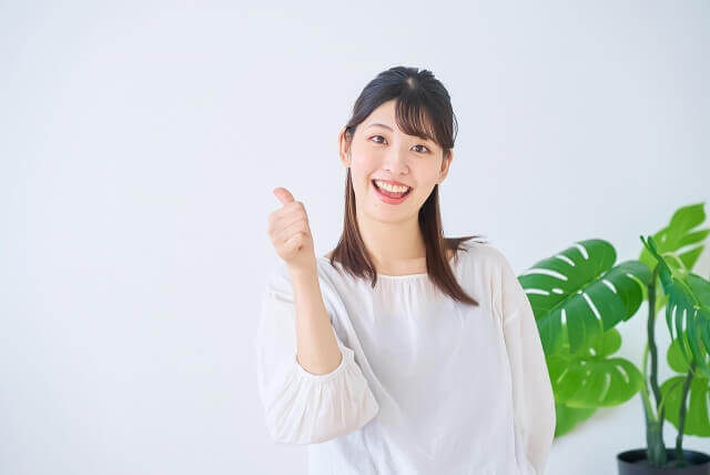 笑顔でサムズアップする女性