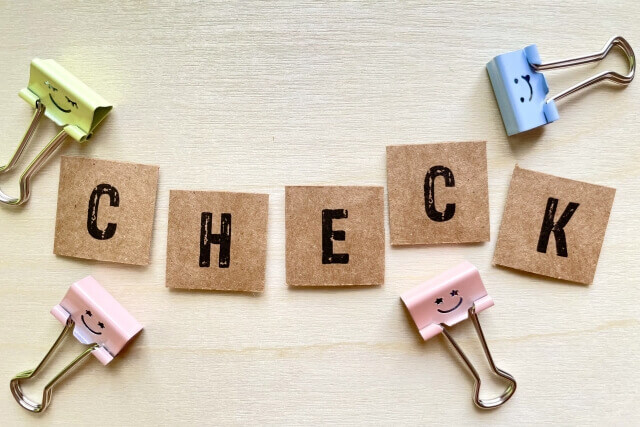 CHECKと書かれているクラフトペーパーとクリップ