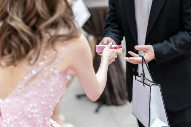 新婦が出席したゲストにプチギフトを渡している
