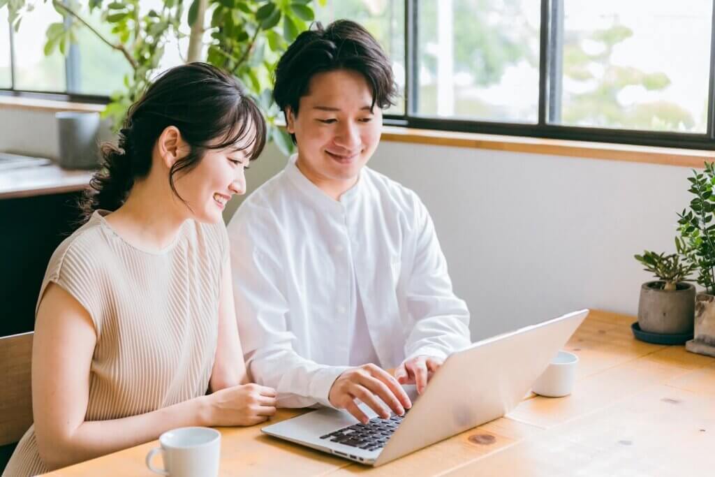 パソコンで検索しているカップル