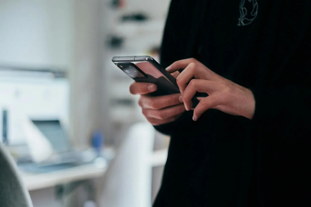 スマートフォンで予約作業を行っている人の手元