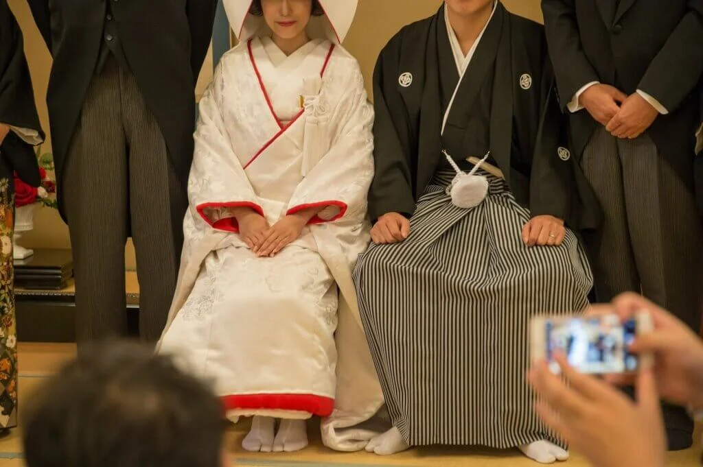 仏前式で羽織袴姿の新郎と白無垢姿の新婦を真ん中にして親族撮影を行っている
