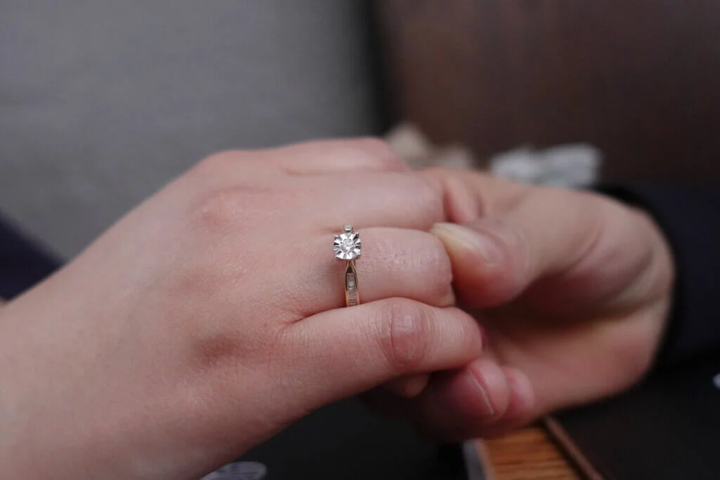 女性の薬指にはめられたダイヤモンドがあしらわれている婚約指輪