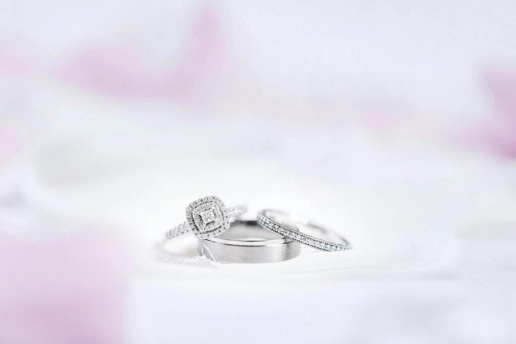 白く、ぼんやりとした背景の中で置かれているたくさんのダイヤモンドが、しあわれた婚約指輪と結婚指輪