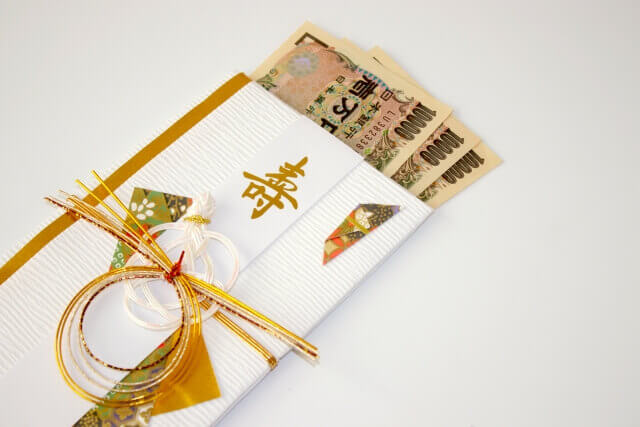 ご祝儀袋からはみ出して、並べられた10,000円札3枚