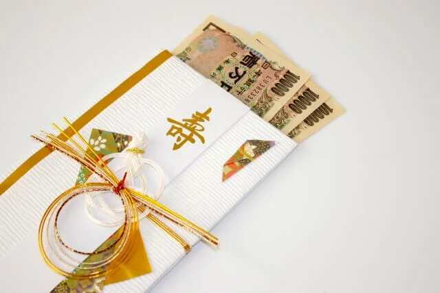 ご祝儀袋からはみ出して、並べられた10,000円札3枚