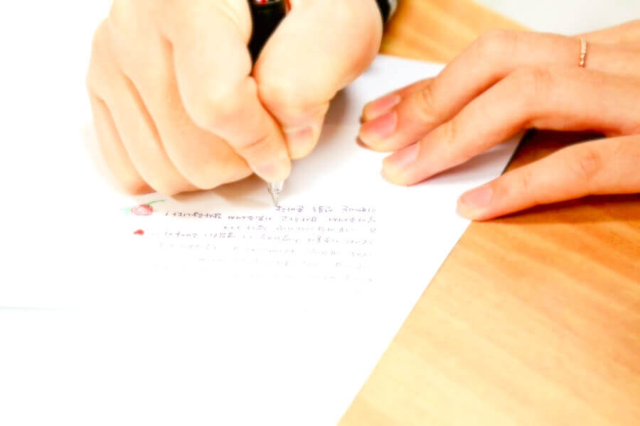 手紙をしたためている女性の手
