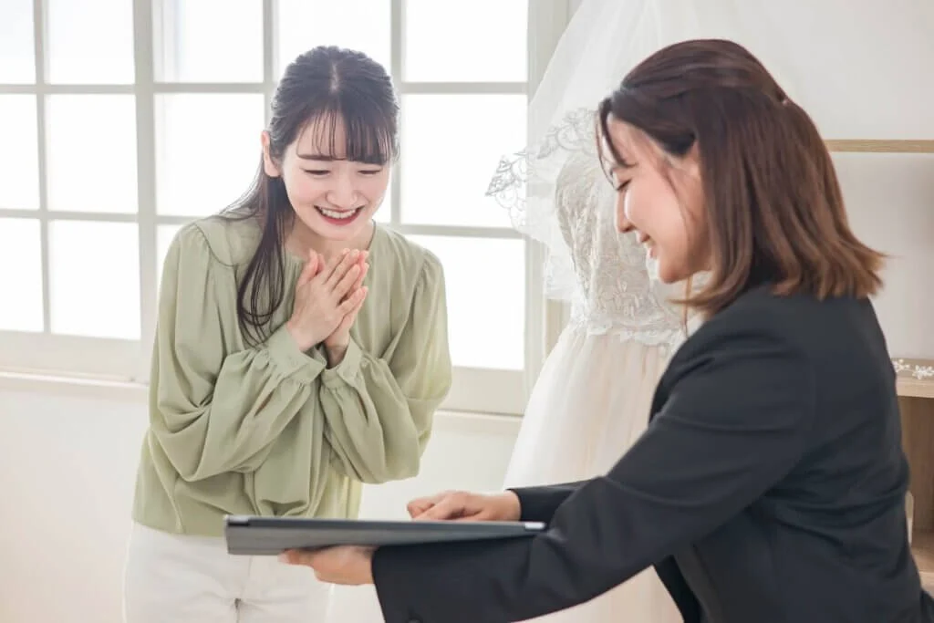 ブライダルフェアについてプランナーから説明を受ける女性