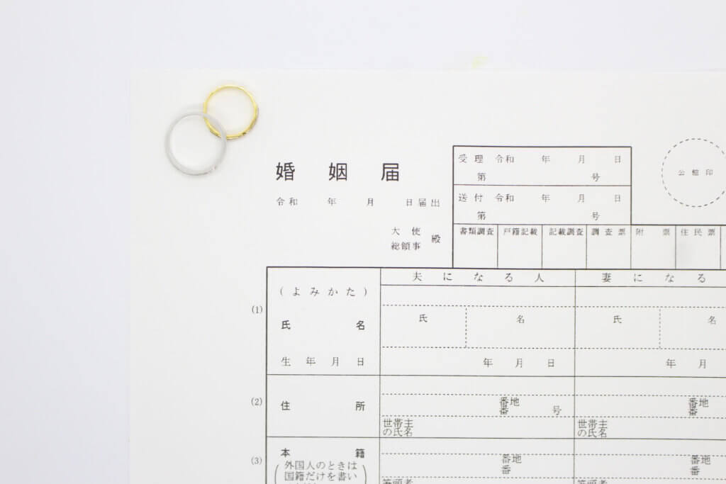 婚姻届の上にペアの結婚指輪が乗せられている