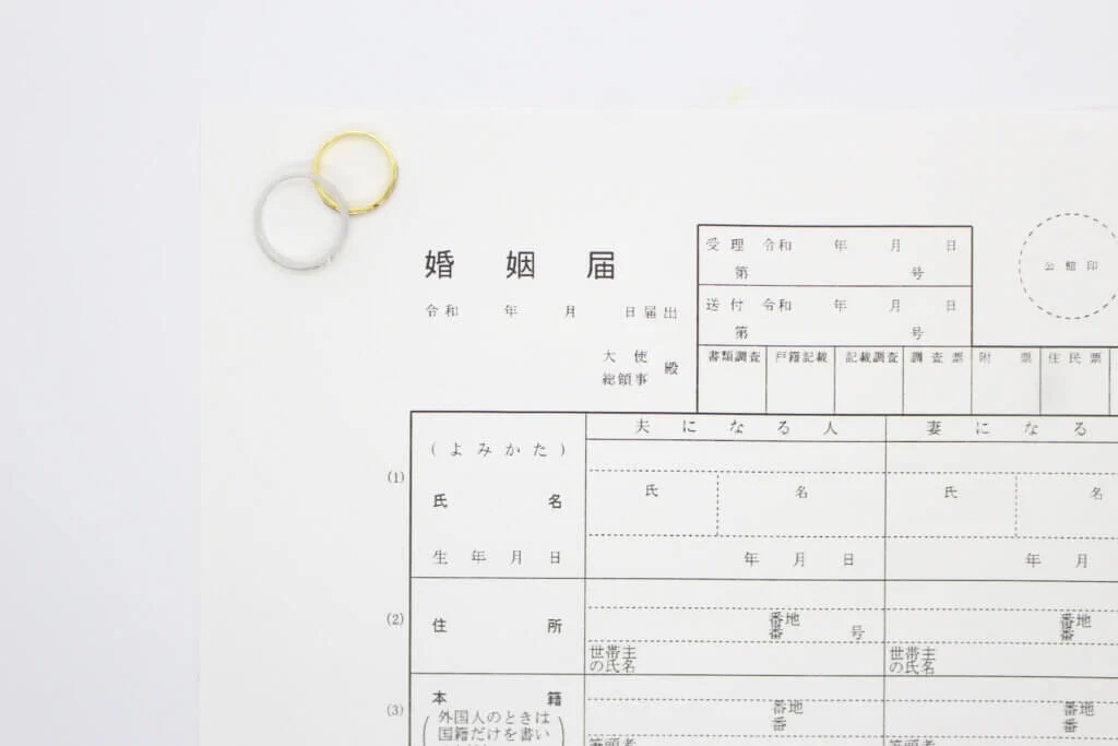 婚姻届の上にペアの結婚指輪が乗せられている