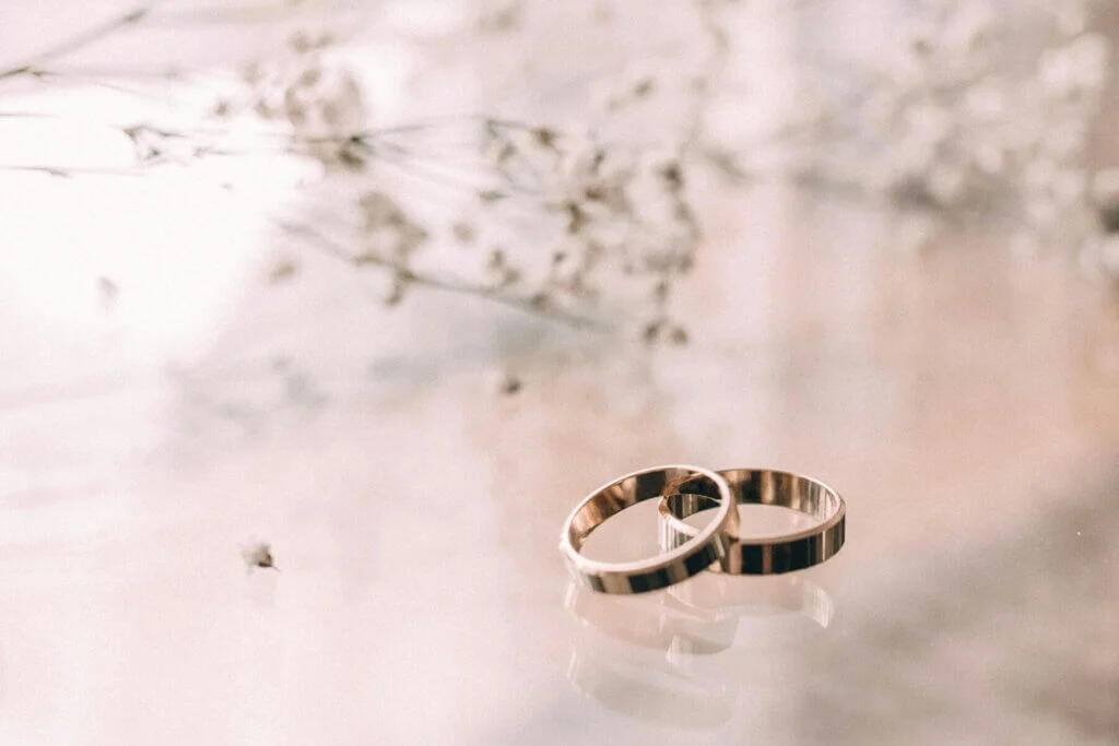 シルバーのペアの結婚指輪がガラスの台にのせられている