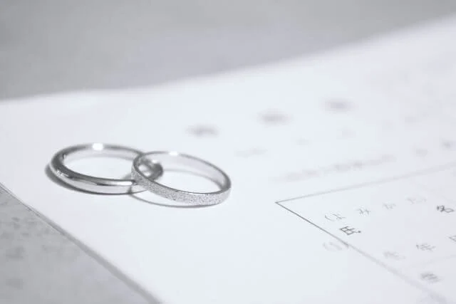 婚姻届の上に乗せられたシルバーのペアの結婚指輪