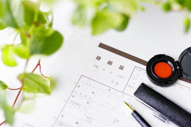 婚姻届とボールペン、印鑑朱肉が置かれている写真