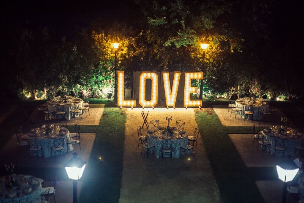 LOVEと表示された大きな電飾が飾られている屋外のナイトウェディング会場