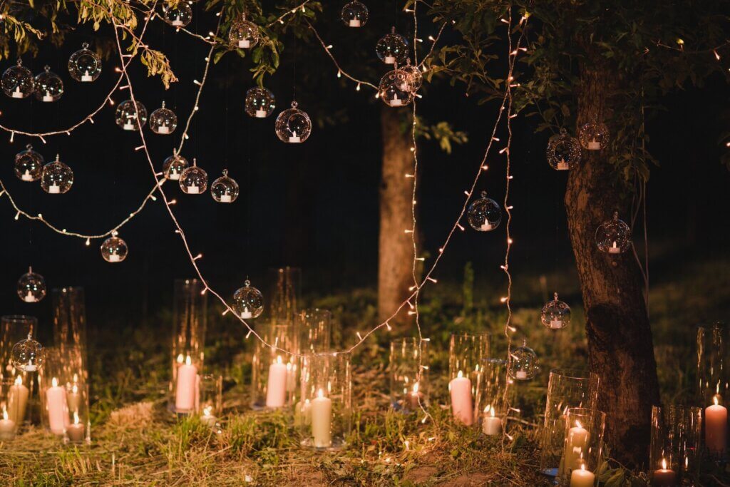 夜の森に飾付けられたたくさんのろうそくと電飾