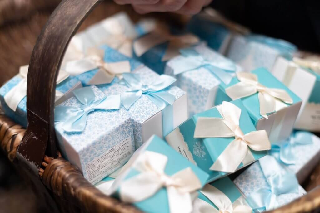 カゴの中にたくさん詰め込まれた白と水色のプチギフトのボックス