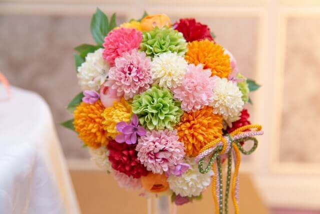 白、ピンク、オレンジ、赤、紫など色とりどりの花で作られた和装用のブーケ