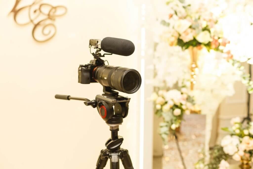 披露宴会場内に三脚の上で設置された望遠レンズと集音器が付いているカメラ