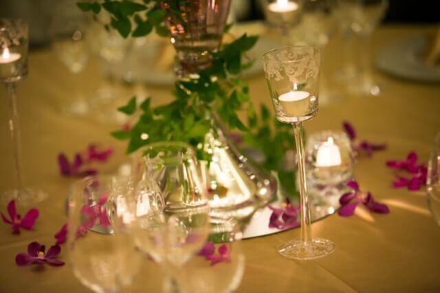 暗転した披露宴会場でテーブルの上に置かれたガラスの中のキャンドル