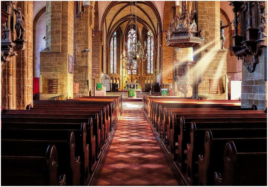 右側の窓から光が差し込んでいる荘厳で大きなチャペル。