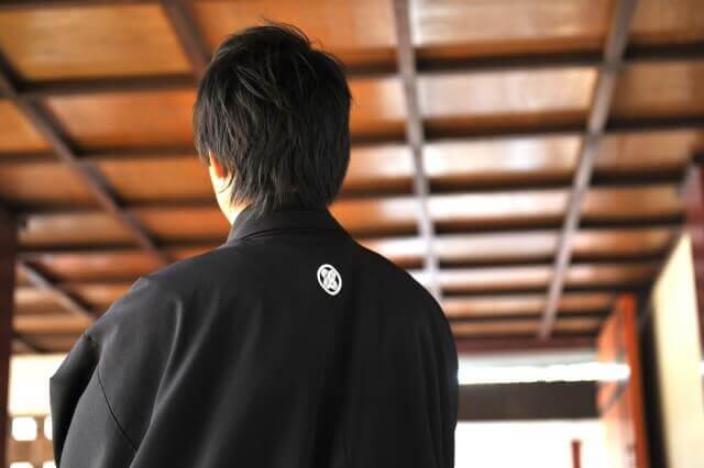 和の会場で黒の紋付姿で立つ新郎