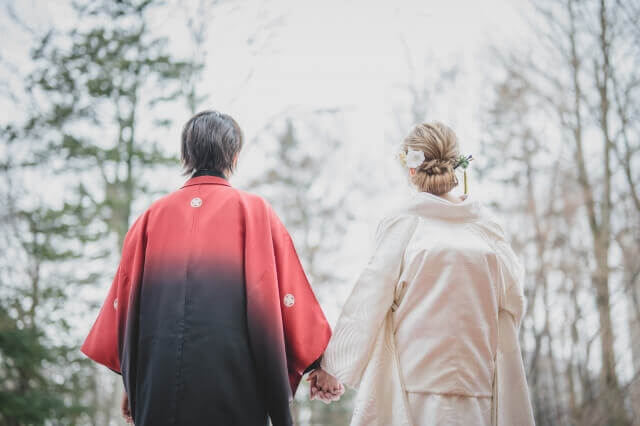 赤い紋付き袴姿の新郎と洋髪で白無垢姿の新婦