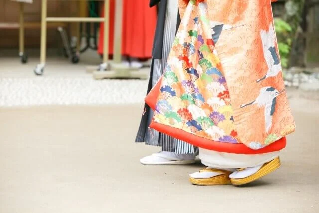 紋付き袴と色打掛で歩いている新郎と新婦