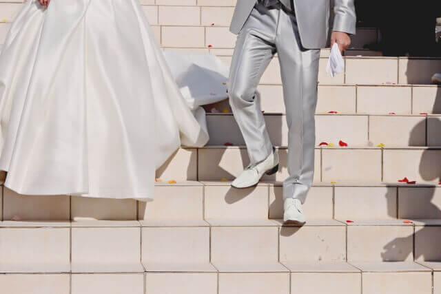 白い階段を降りてくる。シルバーのタキシードに身を包んだ新郎と純白のウェディングドレスの新婦。