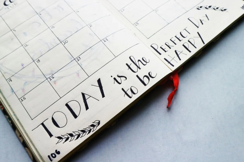 TODAY is the Perfect Day to be HAPPY と書かれたスケジュール帳が開かれている