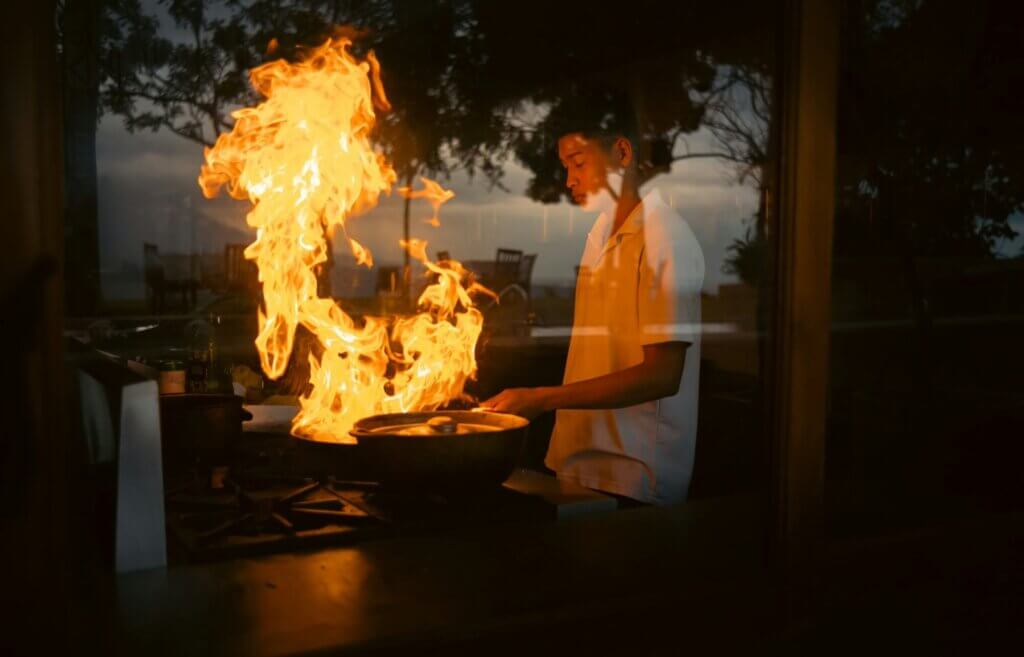 ライブティーチインでシェフが大きな炎をあげて料理している