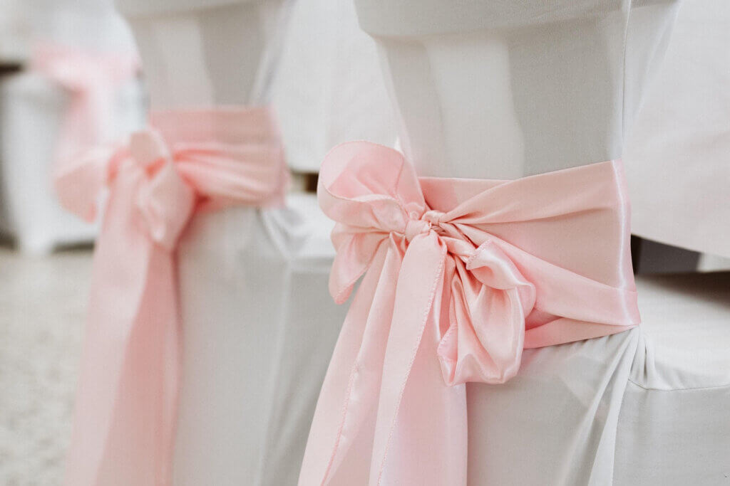 結婚式のゲスト席に巻かれたピンクの大きなリボン