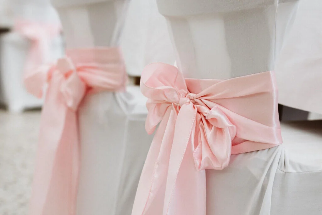 結婚式のゲスト席に巻かれたピンクの大きなリボン