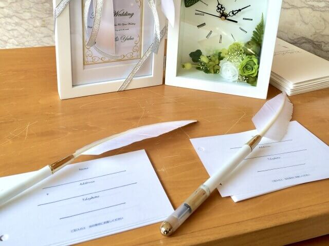 白い羽根のついたペンとゲストが署名するシート
