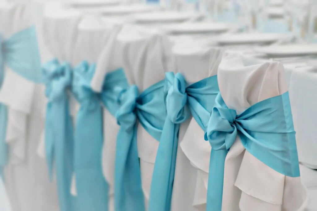 結婚式の流しスタイルのゲストでテーブルの椅子にブルーのリボンがかけられている