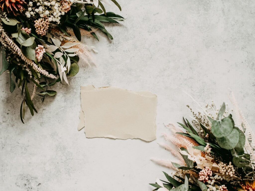 手でちぎられたようなオーガニックな紙が置かれ、周りにボタニカルな植物が置かれている