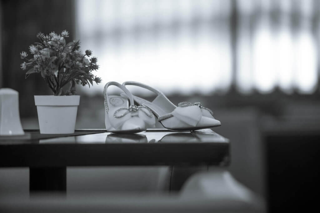 控室のテーブルの上に置かれた白い新婦のハイヒールのモノクロの写真
