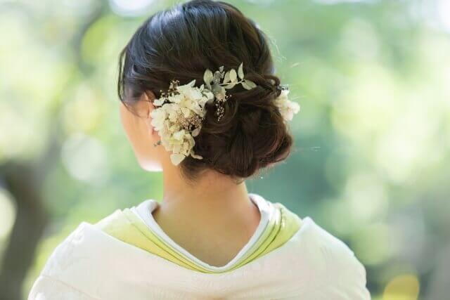 白無垢姿で洋髪に白い花をあしらったスタイルで後ろ姿の新婦