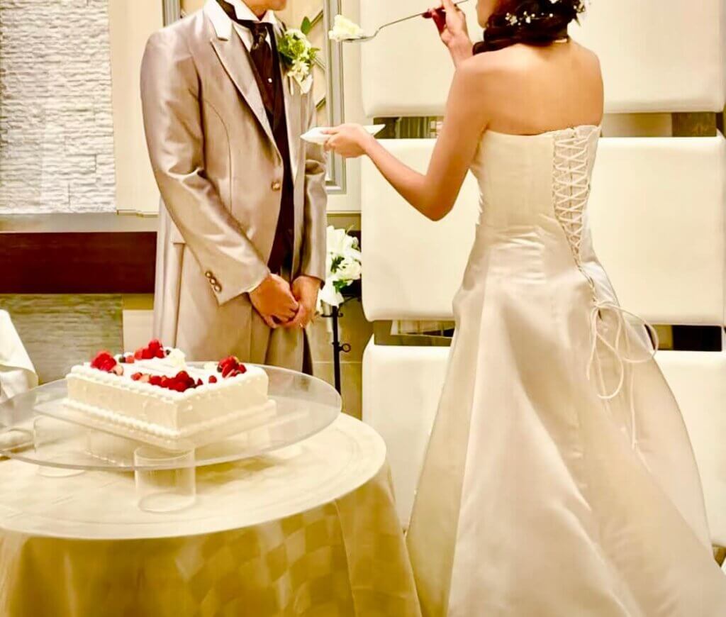 新譜が大きなスプーンにウェディングケーキを作って新郎に食べさせようとしているファーストバイトのシーン。