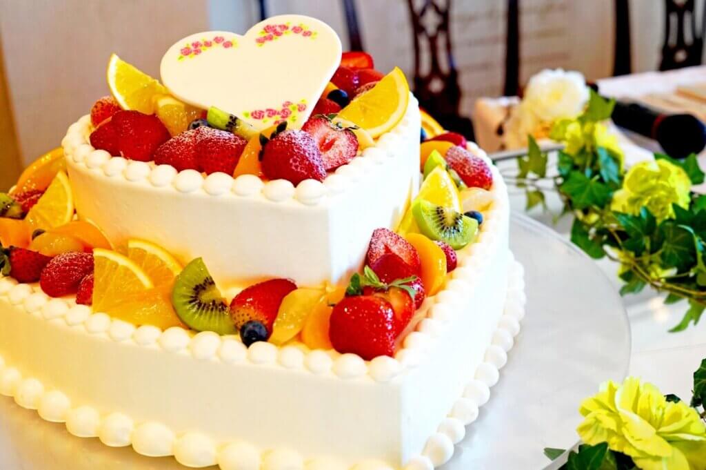 たくさんのフルーツが盛り付けられているハートの形をした2段型のケーキ