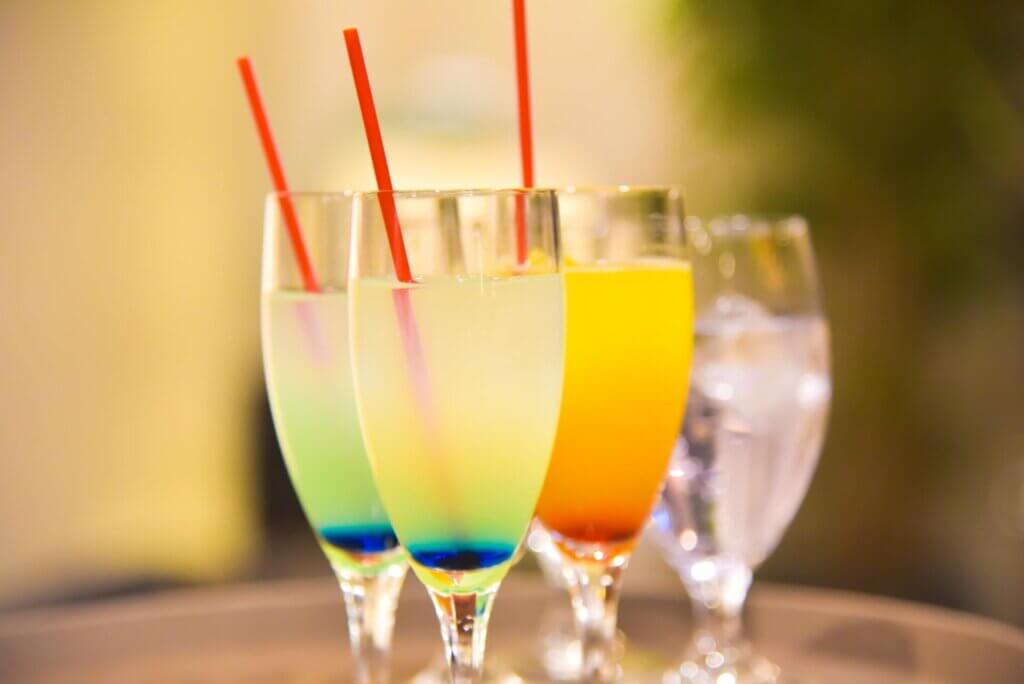 縦長のシャンパン、グラスにブルー系、イエロー系のノンアルコールカクテルが3つ並んでいる