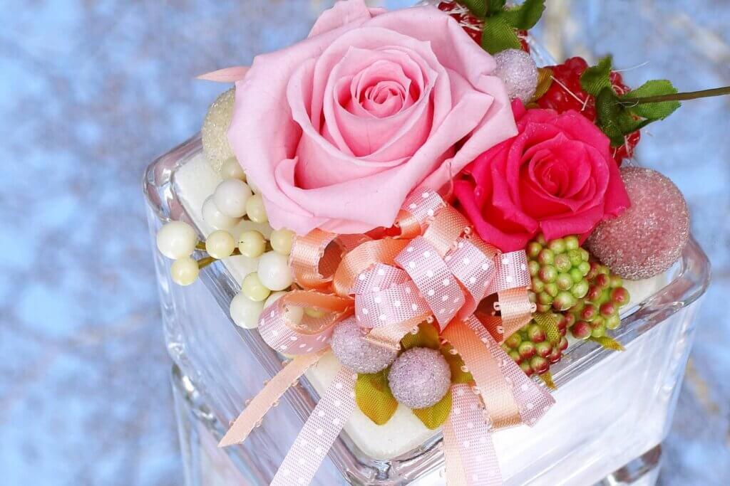 四角いガラスケースにコーディネイトされたピンクと赤のプリザーブドフラワー