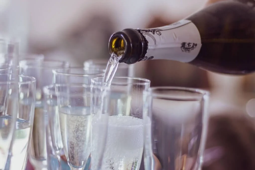 たくさんのシャンパングラスにシャンパンが注がれている
