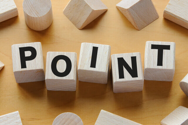 木製のブロックを並べて「POINT」という文字を作った、明るい木目調の背景のクローズアップ画像。