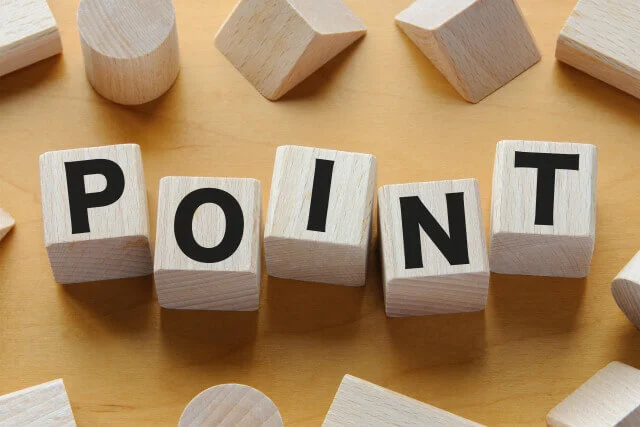 木製のブロックを並べて「POINT」という文字を作った、明るい木目調の背景のクローズアップ画像。