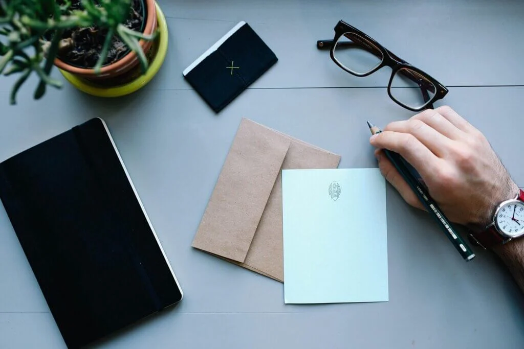 デスクで新婦へのサプライズレターを、心を込めて書いている新郎の手元