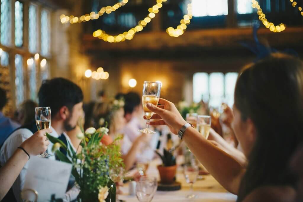 結婚披露宴の会場で、笑顔で乾杯するゲストたち。祝福に包まれた温かい雰囲気。