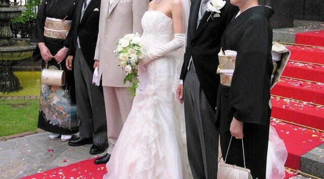 結婚式で両親と並ぶ新郎新婦の家族集合写真