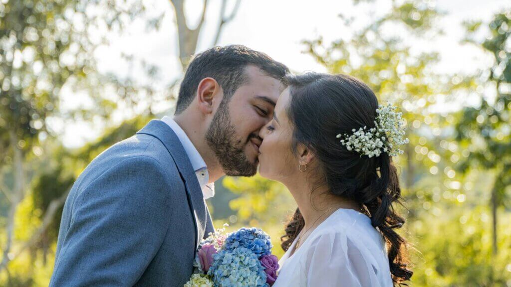 挙式でキスを交わす新郎新婦と髪に飾ったかすみ草